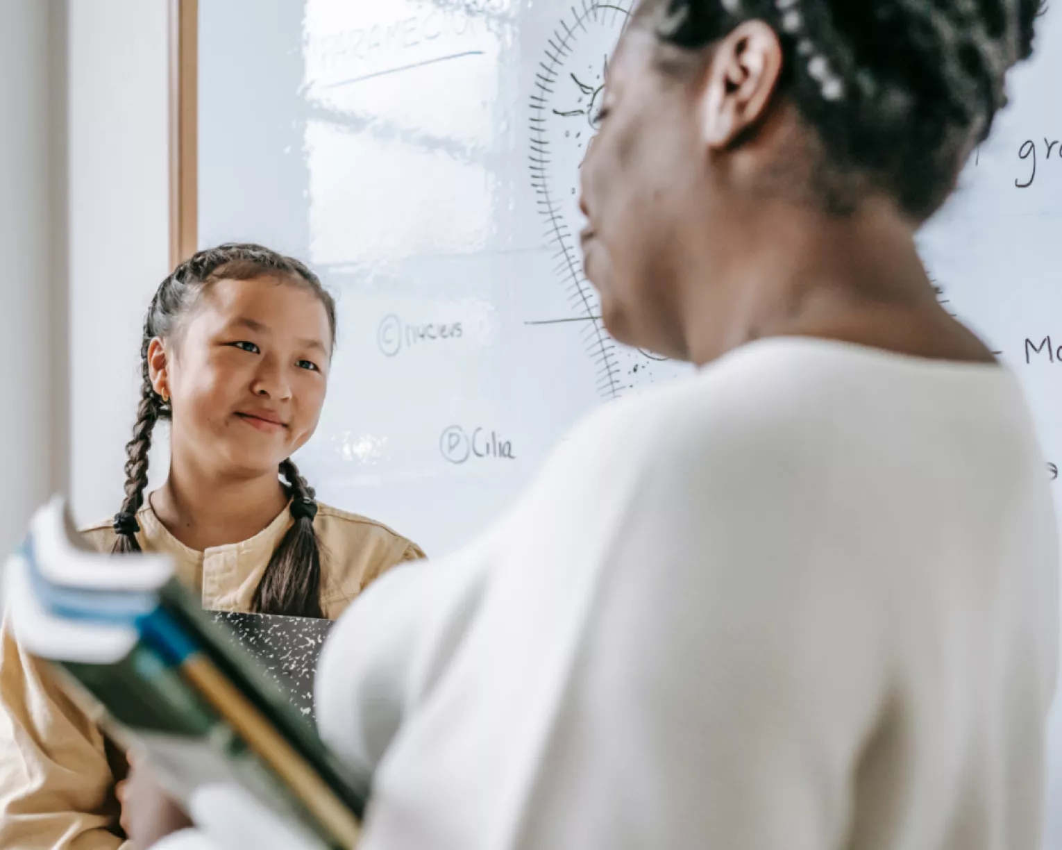 A student looks over at a special education paraprofessional.