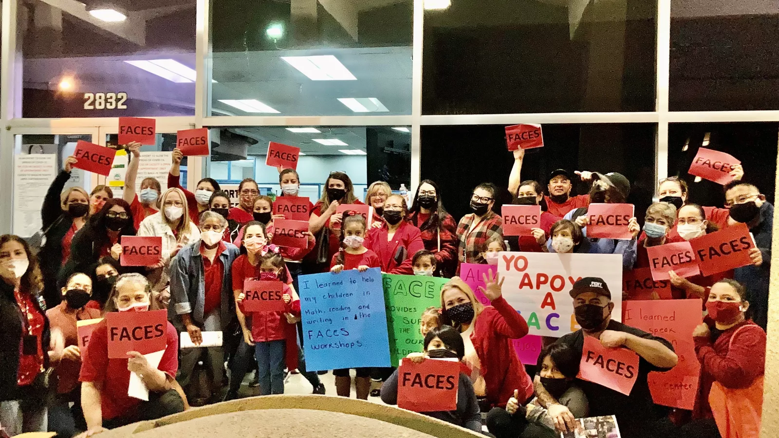 Members pose with signs as they advocate to keep the FACES program