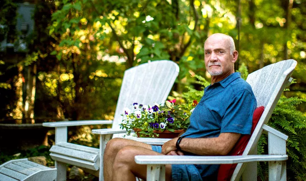 Eric Dreier sitting on an Adirondack chair in his back yard.