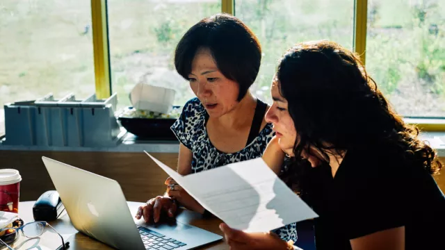 Two members sit looking over a contract