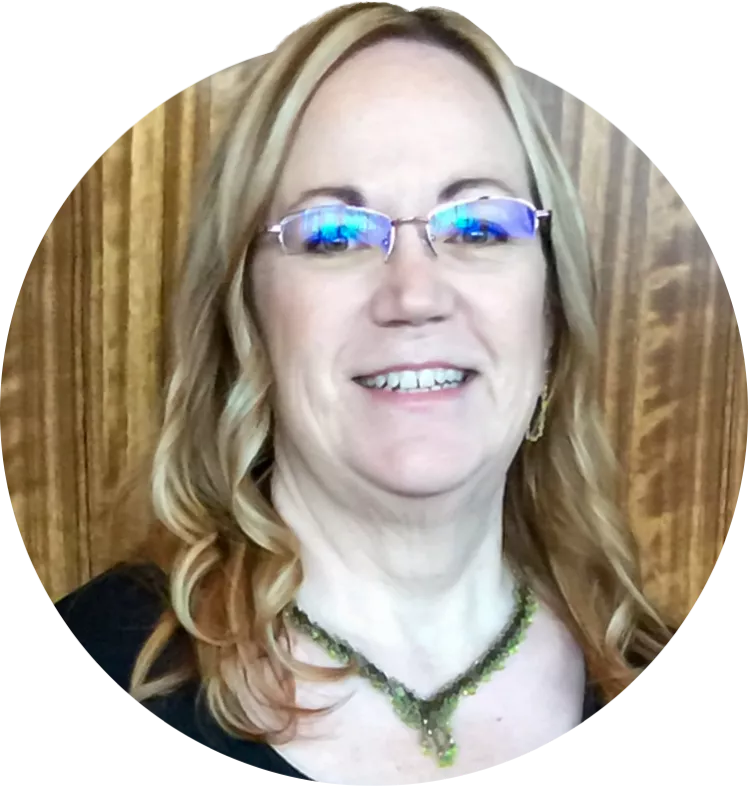 ESEA President Jan Giles smiles for a picture in front of a wood background.