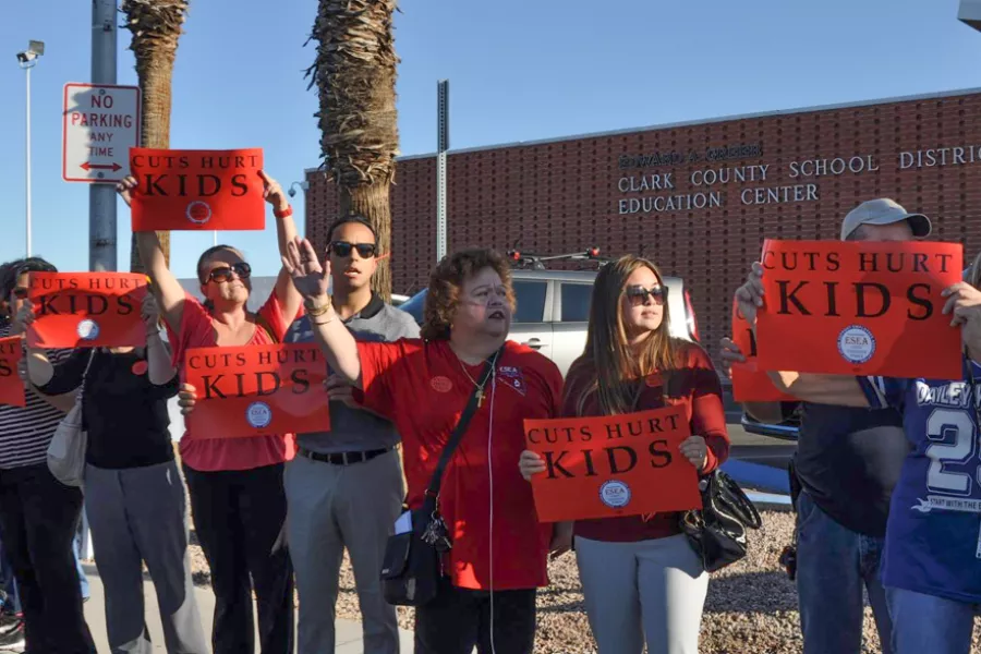 A group of folks pose with signs to advocate for students